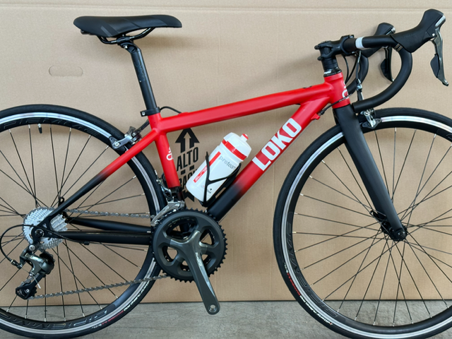 Bici Loko rossa da strada con borraccia.